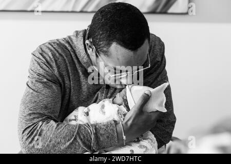 Papa afro-américain tient et embrasse le nouveau-né pour la première fois Banque D'Images