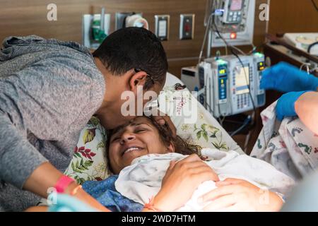 Couple multiracial s'embrassant après avoir accouché à l'hôpital Banque D'Images