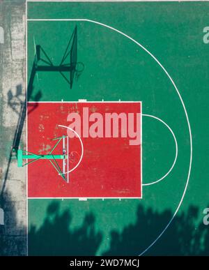 Un terrain de basket-ball dynamique avec un sol vert vif et une surface rouge contrastée Banque D'Images