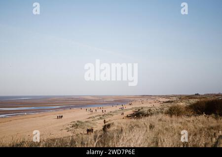 Promeneurs de plage à Hunstanton par une journée ensoleillée d'hiver Banque D'Images