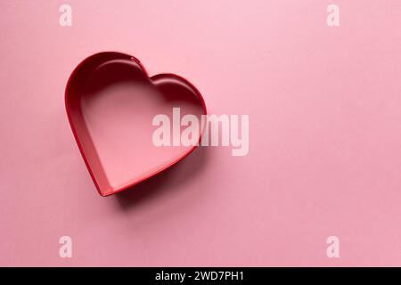 contour de coeur rouge sur un fond rose Banque D'Images