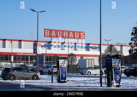 Nachhaltiges Einkaufen im Winter : BAUHAUS-Baumarkt mit Elektro-Ladestation im Schneegestöber , Deutschland, Rhénanie-Palatinat, Speyer, 19.01.2024, DAS Foto zeigt einen BAUHAUS-Baumarkt mit markantem roten Schriftzug, umgeben von einem schneebedeckten Parkplatz und mehreren Autos. Im Vordergrund ist eine Elektrofahrzeug-Ladestation sichtbar, die für das schnelle Laden wirbt. *** Achats durables en hiver BAUHAUS magasin de bricolage avec station de recharge électrique dans les neiges, Allemagne, Rhénanie-Palatinat, Speyer, 19 01 2024, la photo montre un magasin de bricolage BAUHAUS avec un lettrage rouge frappant, surrou Banque D'Images