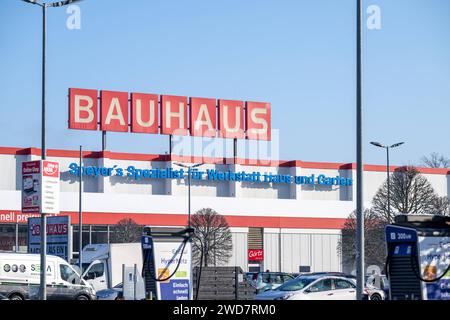 Nachhaltiges Einkaufen im Winter : BAUHAUS-Baumarkt mit Elektro-Ladestation im Schneegestöber , Deutschland, Rhénanie-Palatinat, Speyer, 19.01.2024, DAS Foto zeigt einen BAUHAUS-Baumarkt mit markantem roten Schriftzug, umgeben von einem schneebedeckten Parkplatz und mehreren Autos. Im Vordergrund ist eine Elektrofahrzeug-Ladestation sichtbar, die für das schnelle Laden wirbt. *** Achats durables en hiver BAUHAUS magasin de bricolage avec station de recharge électrique dans les neiges, Allemagne, Rhénanie-Palatinat, Speyer, 19 01 2024, la photo montre un magasin de bricolage BAUHAUS avec un lettrage rouge frappant, surrou Banque D'Images