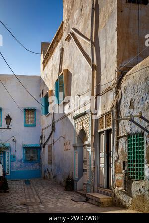 Anciennes maisons blanches, bleues et jaunes dans une cour de la médina de Kairouan, Tunisie. Kairouan est la 4e ville la plus sainte de l'Islam et est un wor de l'UNESCO Banque D'Images