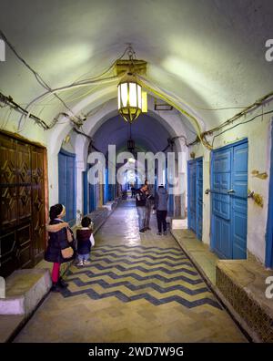 Les enfants se tiennent debout et attendent à l'intérieur de l'ancien souk de parfums couvert dans la médina de Kairouan, Tunisie. Kairouan est la 4e ville sainte de l'Islam et moi Banque D'Images