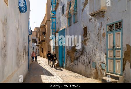 Les Tunisiens passent devant des maisons de l'ancienne médina de Kairouan en Tunisie. Kairouan est la 4e ville sainte de l'Islam et est un Heritag mondial de l'UNESCO Banque D'Images