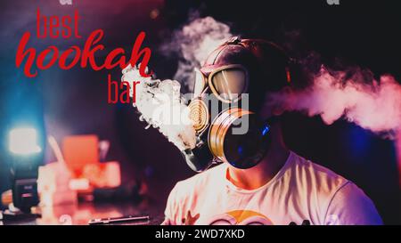 l'homme dans un masque à gaz fume un narguilé et laisse sortir beaucoup de fumée. Concept avec une inscription Best Hookah Bar Banque D'Images