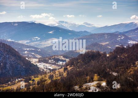 paysage de campagne des carpates au début du printemps. paysage rural montagneux de l'ukraine en mars. collines avec forêt sans feuilles. alpin enneigé Banque D'Images