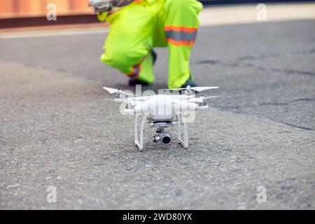 Travailleur du personnel utilisant le système d'imagerie aérienne Drone dans la cour à conteneurs du port. Technologie de garde aérienne UAV Patrol pour la zone de surveillance et de sécurité à logis Banque D'Images