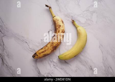 comparer une banane pourrie avec une banane mûre sur fond blanc Banque D'Images