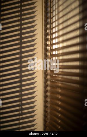 Stores sur la fenêtre. Lumière à travers les stores. Fenêtre le matin. Détails d'un intérieur régulier. Banque D'Images