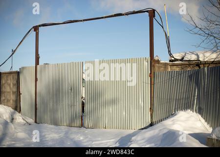 Portails en acier. Porte en hiver. Clôture autour de la ferme. Profil métallique . Banque D'Images