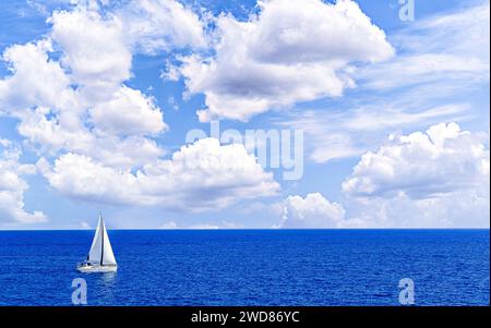 Bateau, voilier naviguant sur la plage de Majorque sous un ciel bleu avec des nuages blancs Banque D'Images