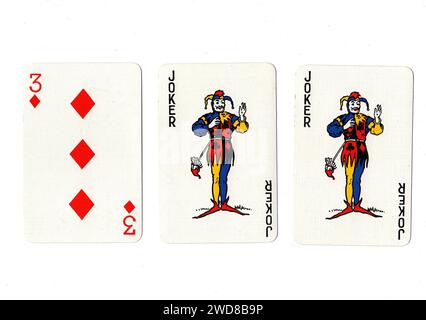 Cartes à jouer vintage montrant une paire de jokers et un rouge trois isolé sur un fond blanc. Banque D'Images