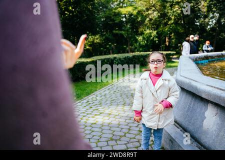 Portrait fille triste du syndrome de Down debout devant sa mère avec un visage triste. L'enfant handicapé est méchant et n'écoute pas sa mère Banque D'Images