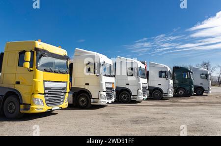6 camions garés magnifiquement dans une rangée par une journée ensoleillée Banque D'Images