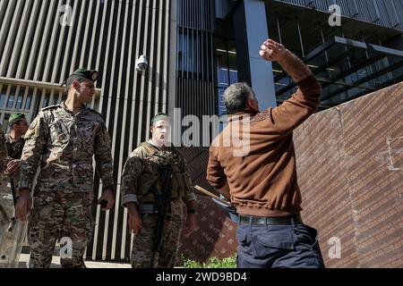 Beyrouth, Liban. 19 janvier 2024. Un manifestant jette des objets sur une banque locale lors d'une manifestation pour exiger l'imposition d'un calendrier pour restituer les économies des déposants. Les protestations des déposants contre les banques se sont exprimées régulièrement depuis les restrictions imposées par les banques libanaises en 2019, au début d’une crise économique sans précédent dans laquelle le Liban est encore enchevêtré. Crédit : Marwan Naamani/dpa/Alamy Live News Banque D'Images