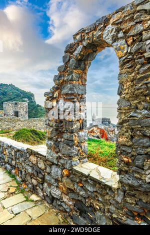 Portovenere, Italie scène côtière avec des ruines regardant vers Chiesa di San Pietro dans la mer Méditerranée. Banque D'Images