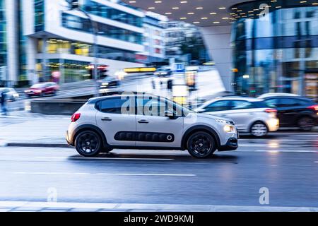 Innerstädtische Straße mit Fahrzeugen, moderne Architektur am Abend. Bewegungsunschärfe. Citroën. // 17.01.2024 : Stuttgart, Bade-Württemberg, Deutschland. *** Rue de la ville avec des véhicules, architecture moderne dans la soirée Motion Blur Citroen 17 01 2024 Stuttgart, Baden Württemberg, Allemagne Banque D'Images