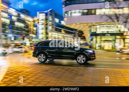 Innerstädtische Straße mit Fahrzeugen, moderne Architektur am Abend. Bewegungsunschärfe. // 17.01.2024 : Stuttgart, Bade-Württemberg, Deutschland. *** Rue de la ville avec des véhicules, architecture moderne dans la soirée Motion blur 17 01 2024 Stuttgart, Baden Württemberg, Allemagne Banque D'Images