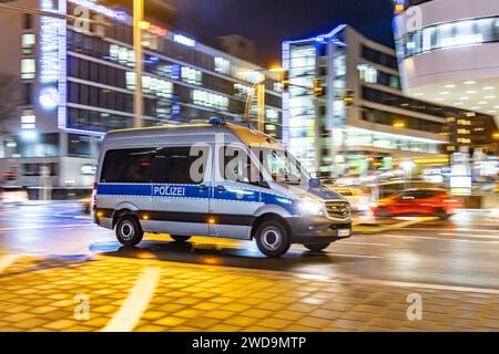 Innerstädtische Straße mit Fahrzeugen, moderne Architektur am Abend. Bewegungsunschärfe. Polizeiauto. // 17.01.2024 : Stuttgart, Bade-Württemberg, Deutschland. *** Rue de la ville avec des véhicules, architecture moderne dans le soir Motion Blur voiture de police 17 01 2024 Stuttgart, Baden Württemberg, Allemagne Banque D'Images