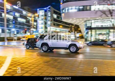 Innerstädtische Straße mit Fahrzeugen, moderne Architektur am Abend. Bewegungsunschärfe. SUV. // 17.01.2024 : Stuttgart, Bade-Württemberg, Deutschland. *** Rue intérieure avec des véhicules, architecture moderne dans le soir Motion Blur SUV 17 01 2024 Stuttgart, Baden Württemberg, Allemagne Banque D'Images