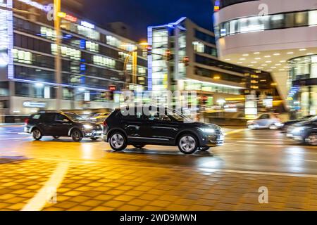 Innerstädtische Straße mit Fahrzeugen, moderne Architektur am Abend. Bewegungsunschärfe. // 17.01.2024 : Stuttgart, Bade-Württemberg, Deutschland. *** Rue de la ville avec des véhicules, architecture moderne dans la soirée Motion blur 17 01 2024 Stuttgart, Baden Württemberg, Allemagne Banque D'Images