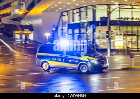 Innerstädtische Straße mit Fahrzeugen, moderne Architektur am Abend. Bewegungsunschärfe. Polizeifahrzeug. // 17.01.2024 : Stuttgart, Bade-Württemberg, Deutschland. *** Rue de la ville avec des véhicules, architecture moderne dans le soir Motion Blur véhicule de police 17 01 2024 Stuttgart, Baden Württemberg, Allemagne Banque D'Images