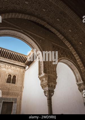 Détail d'une tête de colonne à la cour de la salle dorée (patio del Cuarto Dorado) et façade du palais de Comares aux palais Nasrides de l'Alhambra à la lumière du jour - G. Banque D'Images