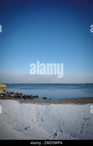 Le phare vert à l'entrée du port de Luebeck en hiver Banque D'Images