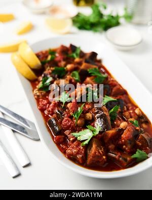 Maghmour ou moussaka libanaise. Plat à base d'aubergines cuites ou frites avec épices, pois chiches et sauce tomate. Les aubergines sont cuites dans de la sauce tomate Banque D'Images