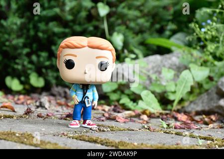 Funko Pop figurine d'action de l'adolescente Max Mayfield avec lecteur de cassette de la série télévisée Stranger Things. Feuilles vertes, route en pierre mousseline, jardin. Banque D'Images