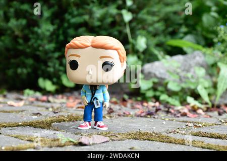 Funko Pop figurine d'action de l'adolescente Max Mayfield avec lecteur de cassette de la série télévisée Stranger Things. Feuilles vertes, route en pierre mousseline, jardin. Banque D'Images