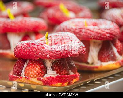 Le pain aux fraises de forme exquise est placé sur un plateau en acier, éclairé par des lumières chaudes, et est très délicieux. Banque D'Images