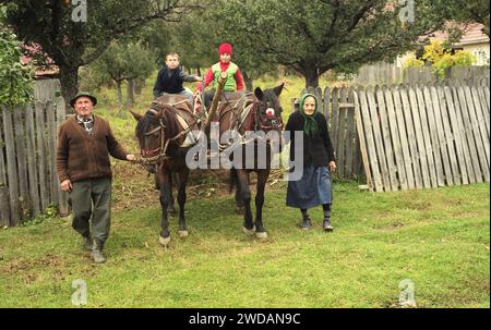 Comté de Vrancea, Roumanie, env. 2002. Grands-parents et petits-enfants sortant de leur verger avec une charrette tirée par des chevaux. Banque D'Images