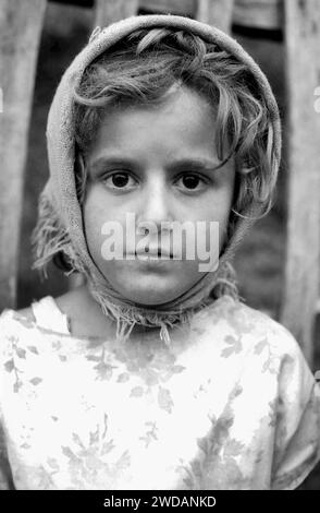 Portrait d'une petite fille portant un foulard dans le comté de Vrancea, Roumanie, vers 1992. Banque D'Images