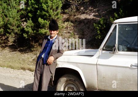 Homme par un véhicule dans le comté de Vrancea, Roumanie, env. 1992 Banque D'Images