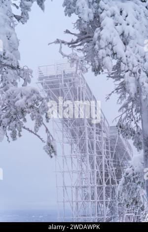 Sommet de la colline de saut à ski gelé en bois par derrière, encadrée par des arbres à Vuokatti, Finlande. Banque D'Images