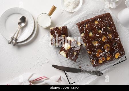 Délicieux gâteau au chocolat fait maison avec des boules de caillé-noix de coco sur une table blanche. Décoré avec croquant à la noix de coco. Banque D'Images