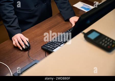 Partiellement de réceptionniste utilisant un ordinateur à la réception dans le hall de l'hôtel Banque D'Images
