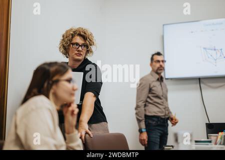 Les gens d'affaires collaborant dans une réunion de salle de conseil pour analyser et discuter des statistiques. Banque D'Images