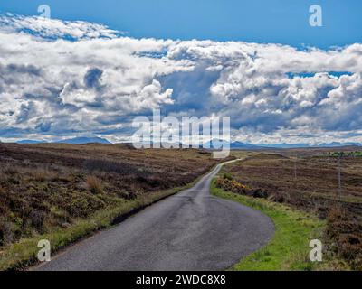 Une route de campagne sinueuse s'étend à travers des prairies vallonnées sous un ciel nuageux spectaculaire. Laide Scotland, Grande-Bretagne Banque D'Images