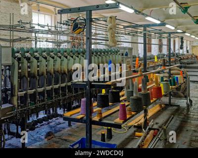 Vue intérieure d'une usine textile avec des machines et des bobines de fil colorées. New Lanark, site du patrimoine mondial de l'UNESCO. Écosse, Grande-Bretagne Banque D'Images