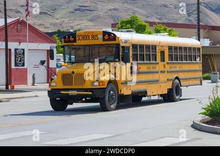 Asotin, WA, États-Unis - 24 mai 2023 ; autobus scolaire américain jaune pour Asotin Anatone district 420 conduisant sur une rue pavée Banque D'Images