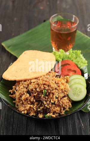 Nasi Goreng Rendang avec craquelin aux crevettes et thé chaud, Rendang est un ragoût de bœuf traditionnel Melayu Minang. Riz frit rendang Banque D'Images