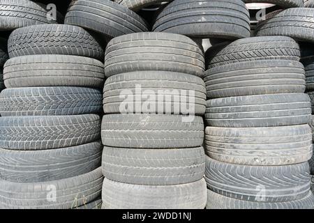 Vieux pneus empilés avec des piles Banque D'Images
