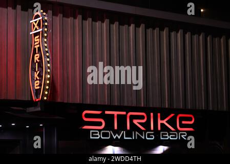 Signalisation lumineuse principalement rouge, avec un panneau ressemblant à une quille à bowling, à l'extérieur du Strike Bowling Bar à QV la nuit Banque D'Images