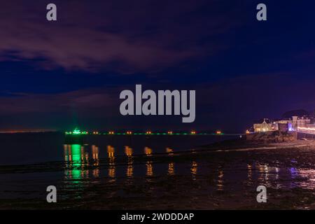 Les lumières colorées sur le Pier se reflètent sur la mer et la boue Banque D'Images