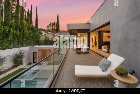 Salon extérieur avec mobilier de jardin et chaises longues au bord de la piscine pour se détendre et s'amuser Banque D'Images