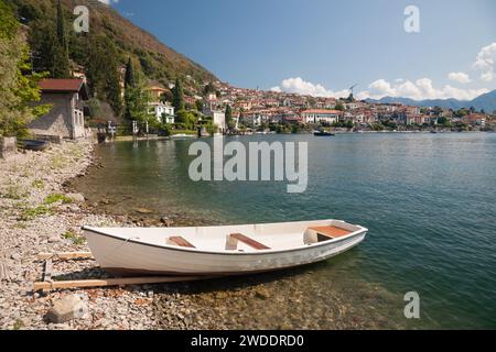 Une vue sur la petite ville d'Ossuccio avec un canot sur la plage par une chaude journée d'été, lac de Côme, Italie Banque D'Images